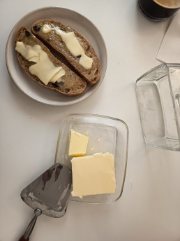 Untar mantequilla con un corta lonchas de queso. Sardinas en Lata